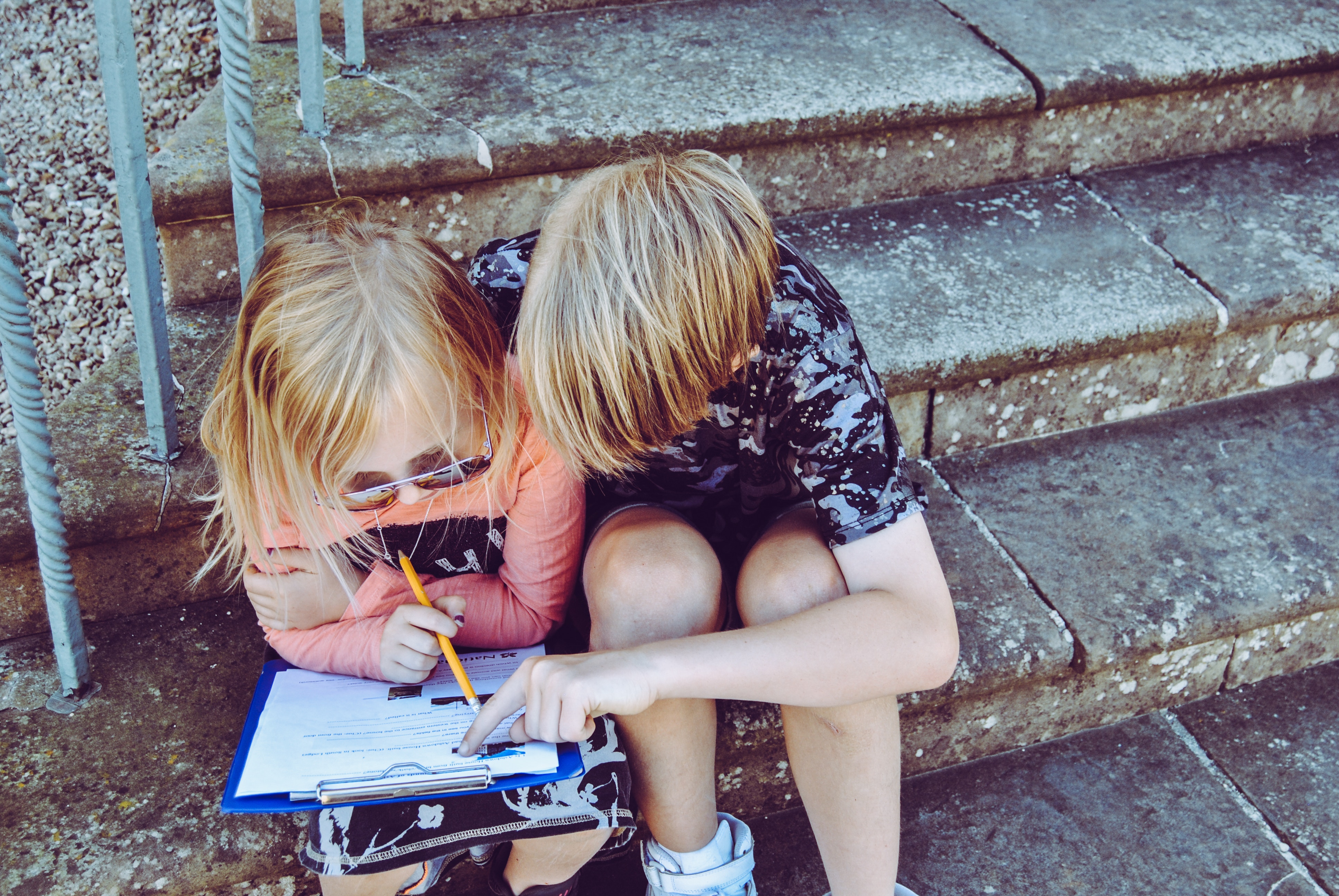 Boy and girl doing their homework in stone stairs