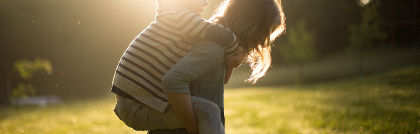 Small boy riding an older girls' back